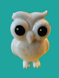 Een wit uiltje in tekenfilm stijl. Grote ogen die het grootste deel van het hoofd beslaan en gouden veertjes op de buik. Op het hoofd zitten wat wilde veren als een soort kapsel.