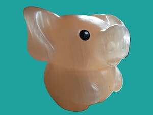 Een varkentje in tekenfilm stijl, oranje gekleurd. Grote oren, grote neus met neusgaten van verschillende grootte, ogen zijn zwart met een wit stipje gemaakt. Het hoofd is net zo groot als het lijfje met de pootjes. Hij staat op zijn achterpoten en de voorpoten liggen over de bolle buik. De steen is wat doorschijnend wat in het zonlicht een mooi effect geeft.