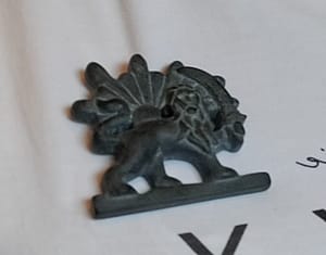 Broche van de Shir Khorshid, de Leeuw met een zwaard in zijn poot en de zon schijnt achter hem. Het is het symbool van Iraans erfgoed. Het is gemaakt uit een stukje zwarte steen.